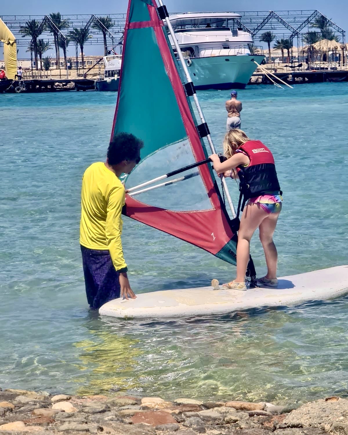 windsurfing lesson Hurghada instructor helping student shallow lagoon Egypt